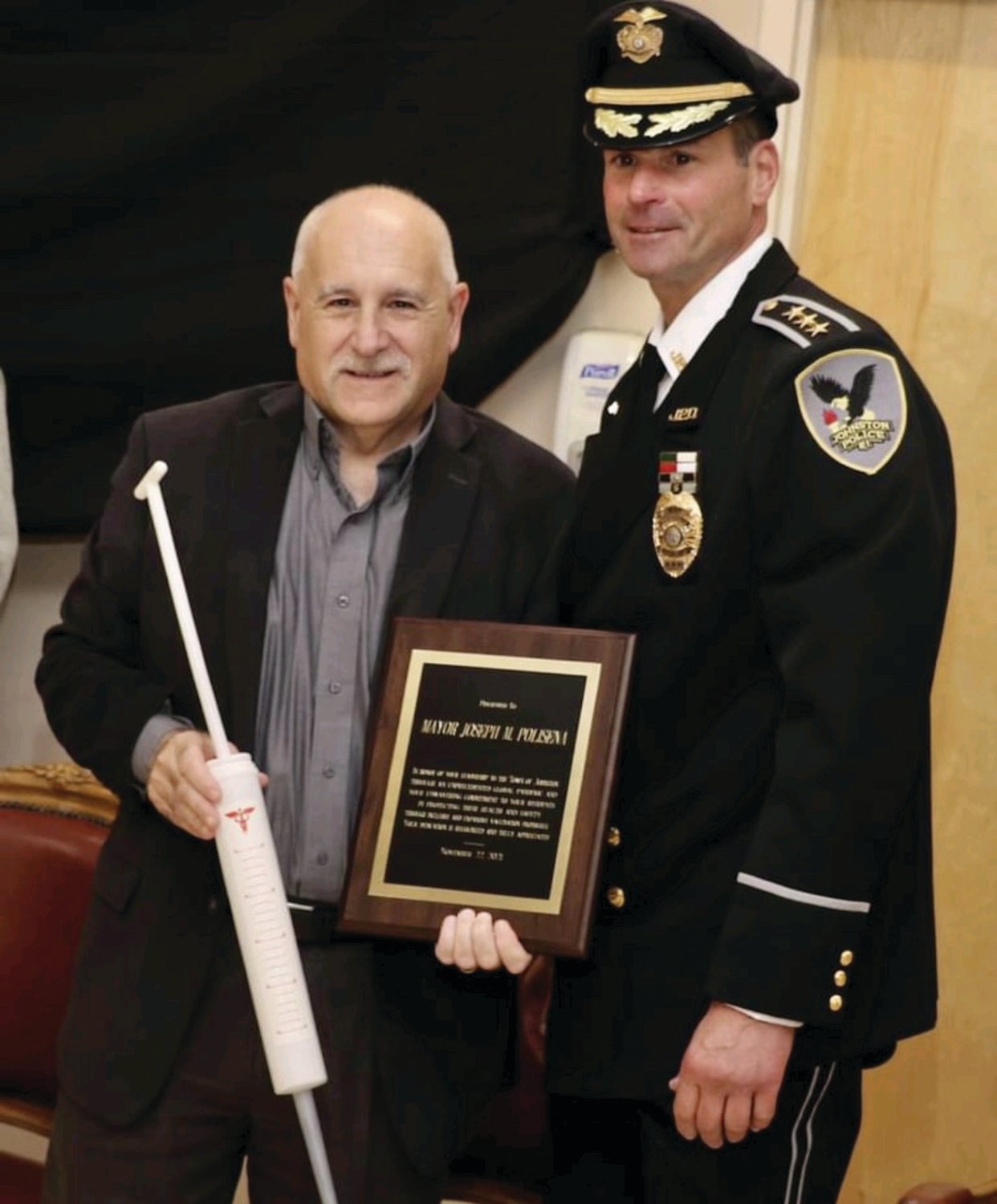 BIG SHOT: Johnston Mayor Joseph M. Polisena in all smiles after receiving two awards — an inflated syringe and the JPD’s Civilians Award for Meritorious Acts — from Police Chief Joseph Razza during the recent Recognition of Excellence Ceremony.